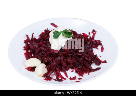 Grated beets with garlic in a plate isolated on white background Stock Photo