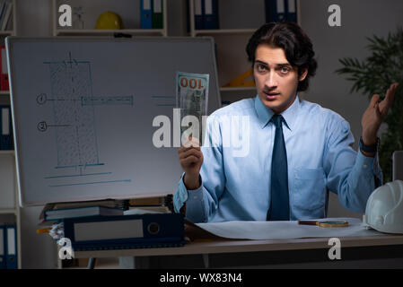 Young male architect working night at office Stock Photo