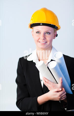 Young female constrcution worker with blueprints Stock Photo