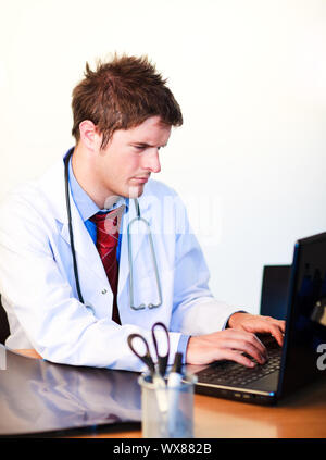 Thoughtful handsome doctor working on a computer in hospital Stock Photo