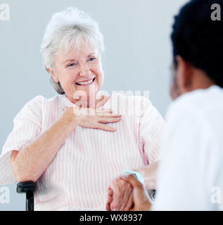 Senior woman sitting on a wheelchair talking with her doctor in a hospital Stock Photo