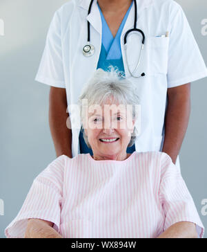 Smiling senior patient sitting on a wheelchair in a hospital Stock Photo