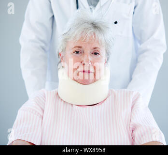 Portrait of a senior woman with a neck brace sitting on a wheelchair in a hospital Stock Photo