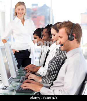 Happy female leader with a team on a call center Stock Photo