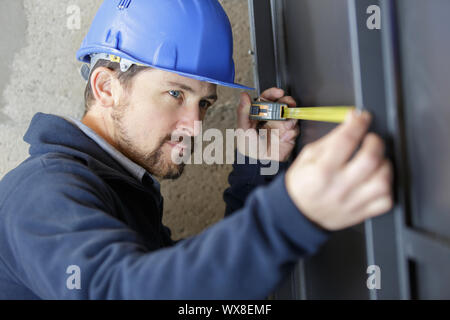 man measuring a wall using a folding ruler Stock Photo