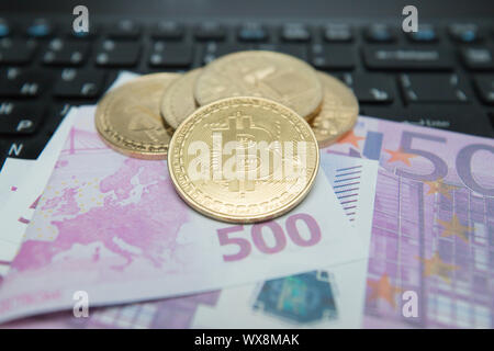 Golden Bitcoin on Euro Banknote. Symbolic image of virtual currency. Stock Photo