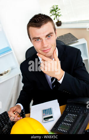 Confident caucasian businessman looking at the camera sitting in his office Stock Photo