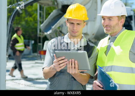 workers on outdoor site looking at tablet Stock Photo