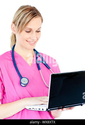 Busy female surgeon using her laptop standing against white background Stock Photo