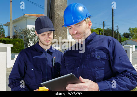 young apprentice at work on construction site with senior engineer Stock Photo