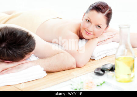 Attractive young couple lying on a massage table in a spa center Stock Photo