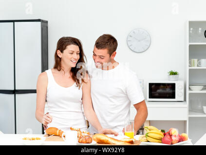 Lovely couple preparing their breakfast together in the kitchen Stock Photo