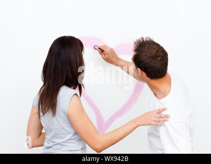 Man Drawing A Heart While His Girlfriend Painting A Wall During A Renovation Stock Photo Alamy