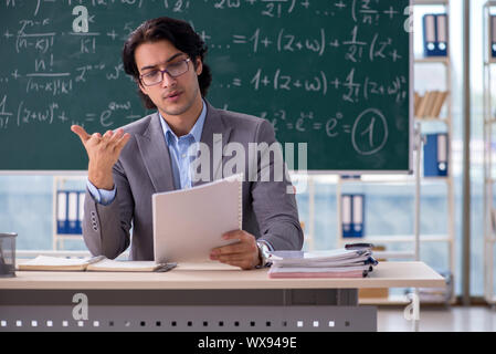 Young handsome math teacher in classroom Stock Photo