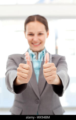 Successful businesswoman doing thumbs up in the office Stock Photo