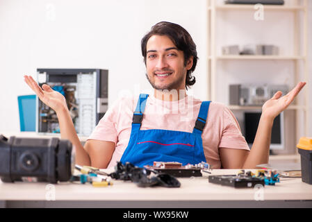 Young male contractor repairing computer Stock Photo