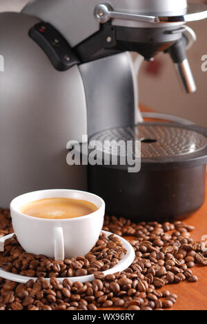 Coffee machine and cup of espresso. Spilled out coffee beans. Stock Photo