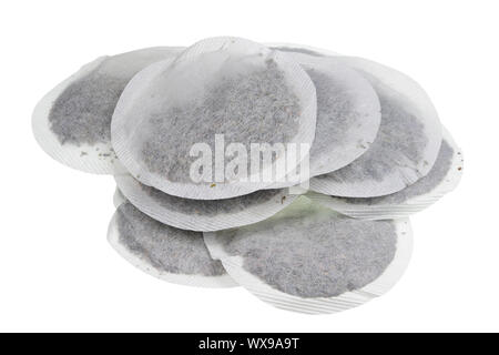 Round paper bags with dry green tea heap isolated macro Stock Photo