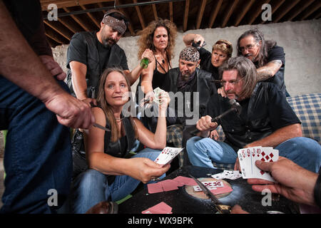 Mature female biker gang member shows cards to aggressive players Stock Photo