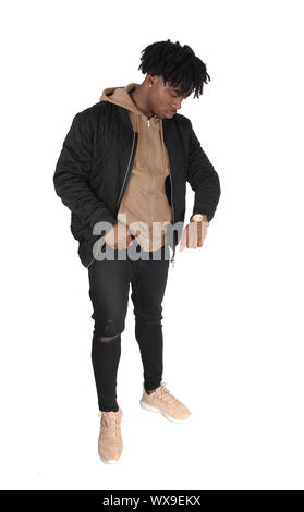 Black man standing in studio looking at his watch Stock Photo