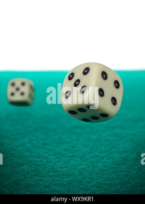 A pair of dices rolling over a green felt. Stock Photo