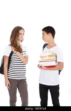 Teenage boy and girl with school supplies talking isolated on white in studio Stock Photo