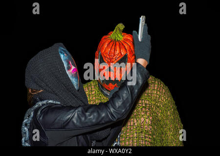 Salem Massachusetts USA 10/31/2015. Someone in costume takeing a selfie with Pumpkin head. Editorial use only Stock Photo