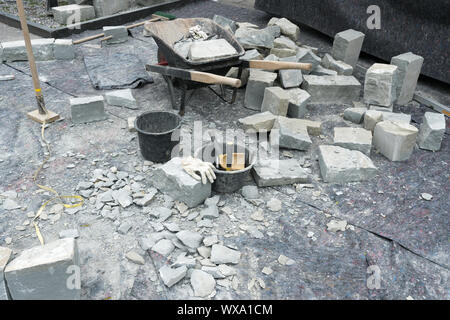 cutting and chopping stones for building a natural rock and stone wall during a landscaping project Stock Photo