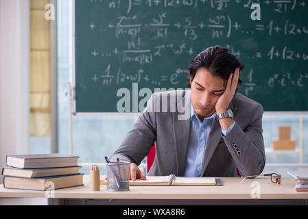 Young handsome math teacher in classroom Stock Photo