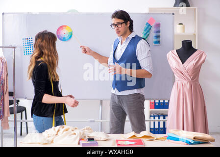 Young male tailor teaching female student Stock Photo