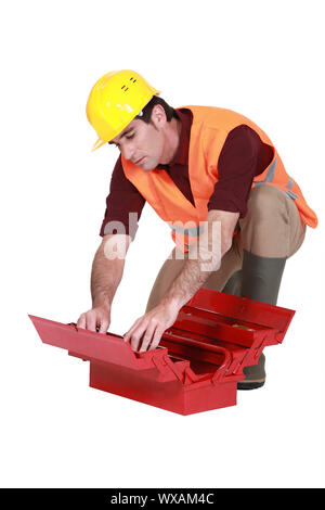 Laborer searching in  a toolbox Stock Photo