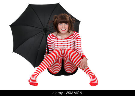 woman in striped clothes holding an umbrella Stock Photo