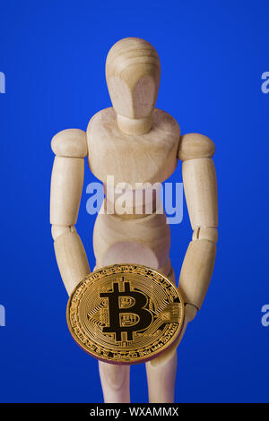 Wooden toy figure with bitcoin on blue Stock Photo