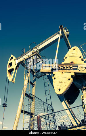 Rocking machine on an oil well. Oil production Stock Photo - Alamy
