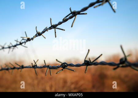 barbed wire on a fence to prevent unauthorized access Stock Photo