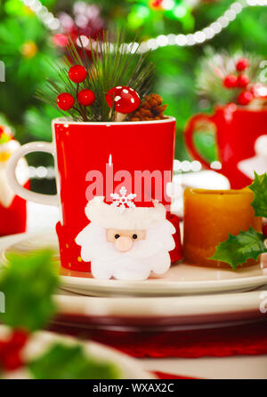 Image of Christmastime decoration for dinner, green decorated Christmas tree near holiday table, New Year party table setting, red and white festive u Stock Photo