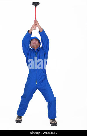 craftsman holding a plunger Stock Photo