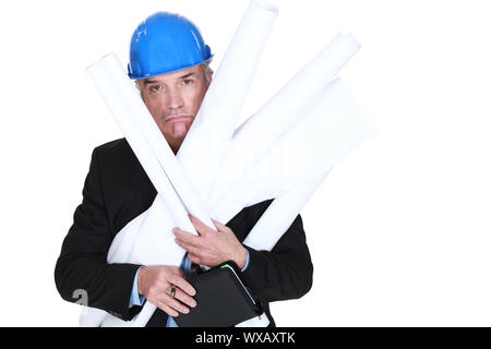 Pouting engineer carrying a stack of rolled-up drawings Stock Photo