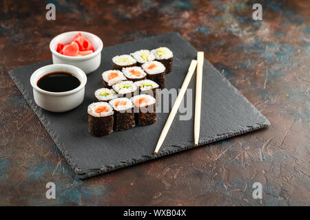 Japanese sushi on a rustic dark background. Stock Photo