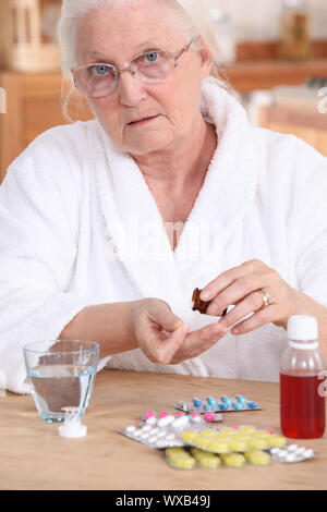 Older woman taking medicine Stock Photo