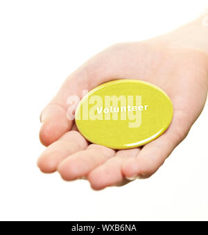 Hand holding green round volunteer button isolated on white Stock Photo