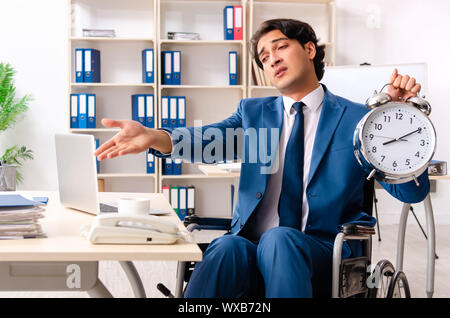 Male employee in wheelchair working at the office Stock Photo