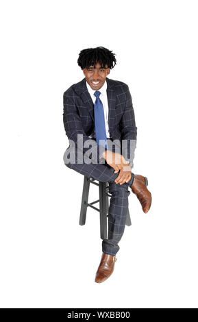 Young good looking black man sitting on chair in suit Stock Photo