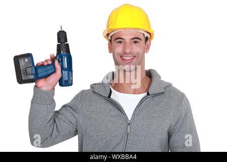 Tradesman holding up a screw gun Stock Photo