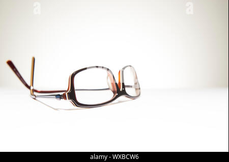 A pair of classic framed reading glasses resting on a white background with space for text Stock Photo