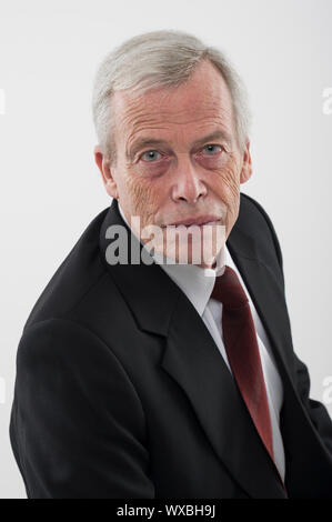High angle studio portrait of a serious handsome grey haired senior man in a suit and tie looking up at the camera Stock Photo