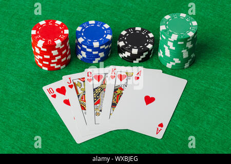 Casino chips and playing cards on green table Stock Photo