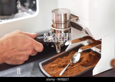 barista holding tamper above portafilter with grinded coffee, espresso, manual  press, arabica Stock Photo by LightFieldStudios