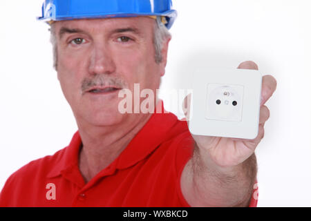 Electrician with a continental two pin wall socket Stock Photo