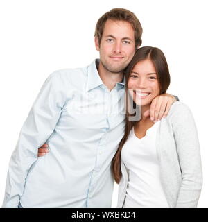 Happy young couple. Portrait of cheerful multiracial couple smiling looking at camera. Asian woman, Caucasian man. Stock Photo